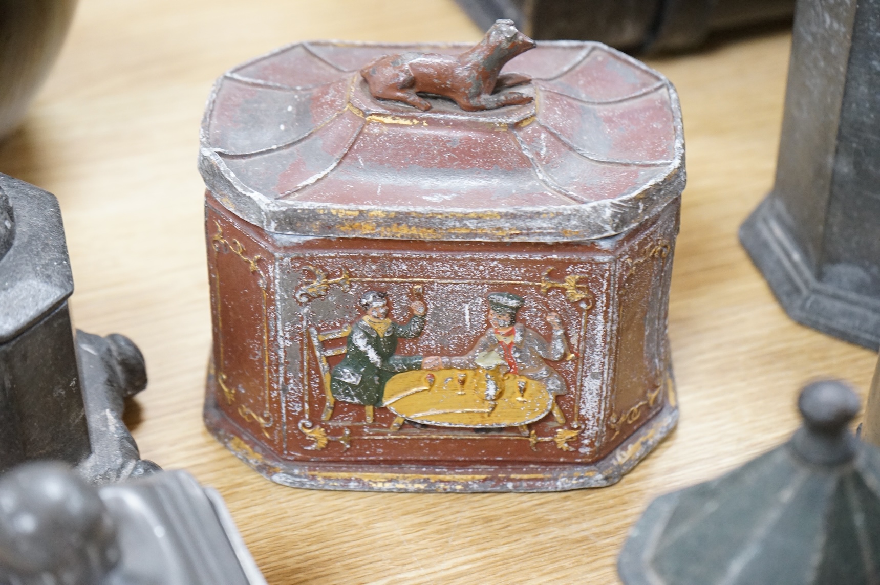 A collection of ten early 19th century lead tobacco boxes, to include an octagonal example, decorated in relief with the remains of red and gilt paint, largest 13cm wide